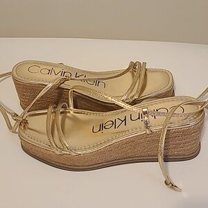 Calvin Klein gold low wedge sandals.